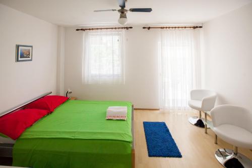a green bed in a white room with a window at Friendly People's Guest House in Zadar
