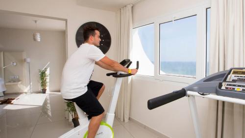 a man is riding a treadmill in a room at ON Hotels Oceanfront Adults Designed in Matalascañas