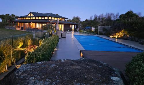 a house with a swimming pool in front of a building at Kākahu Lodge in Geraldine