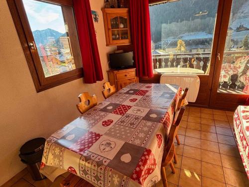 Cette chambre comprend une table avec une couette. dans l'établissement Charmant 2 pièces avec balcon Sud à La Chapelle-d'Abondance - FR-1-692-17, à La Chapelle-dʼAbondance