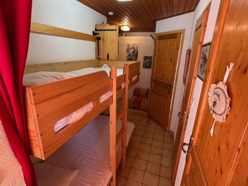 Cette petite chambre comprend 2 lits superposés et une porte. dans l'établissement Charmant 2 pièces avec balcon Sud à La Chapelle-d'Abondance - FR-1-692-17, à La Chapelle-dʼAbondance
