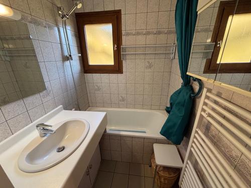 une salle de bain avec un lavabo et une baignoire dans l'établissement Charmant 2 pièces avec balcon Sud à La Chapelle-d'Abondance - FR-1-692-17, à La Chapelle-dʼAbondance