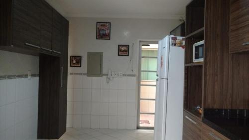 a kitchen with a refrigerator and a tile floor at Mansão gata gaiatta in Belém