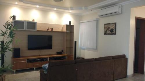 a living room with a couch and a flat screen tv at Mansão gata gaiatta in Belém