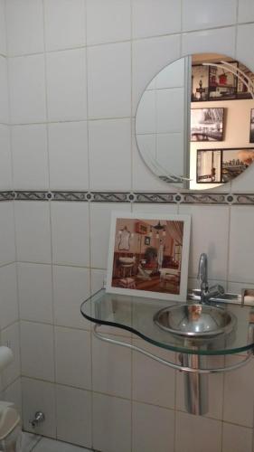 a bathroom with a glass sink and a mirror at Mansão gata gaiatta in Belém
