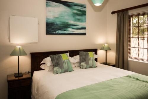- une chambre avec un grand lit et deux lampes dans l'établissement 39 On Nile Guest House, à Port Elizabeth