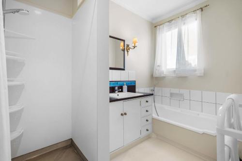 a white bathroom with a tub and a sink at Stunning Lake Views & Hospital Location in Hamilton