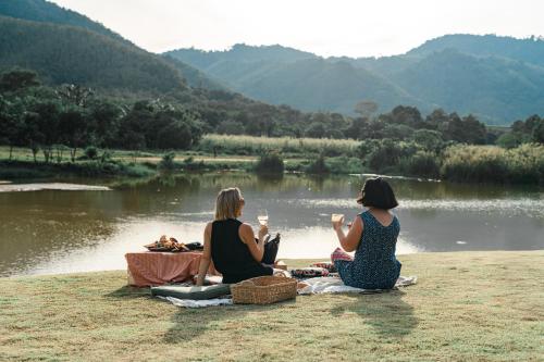 twee vrouwen op het gras naast een meer bij Niran Farm in Koh Lone