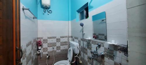 a bathroom with a toilet and a mirror at Selfie n Studio Homestay in Khānāpāra