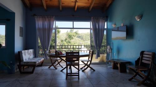 a dining room with a table and chairs and a window at Casa QI in Santa Cruz Huatulco