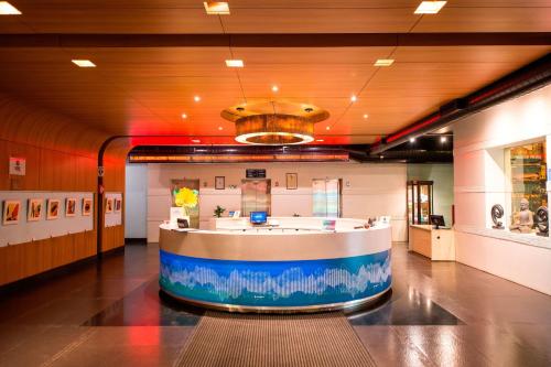 a large lobby with a counter in the middle of a room at Aloft Bengaluru Whitefield in Bengaluru