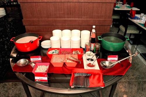 a table with food and bowls and utensils on it at Aloft Bengaluru Whitefield in Bengaluru
