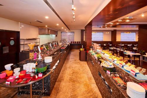 a buffet line in a restaurant with many different foods at Aloft Bengaluru Whitefield in Bengaluru