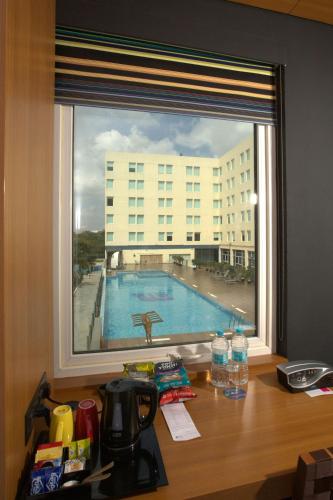 a view of a swimming pool through a window at Aloft Bengaluru Whitefield in Bengaluru