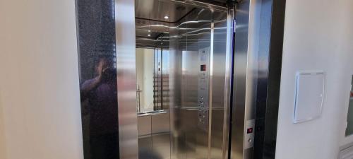 a elevator with a glass door in a room at Apartamento Barra Velha Praia do Tabuleiro in Barra Velha