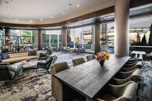 a lobby with a large table and chairs at Renaissance Boston Patriot Place Hotel in Foxborough