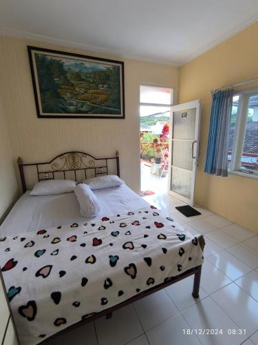 a bedroom with a bed with hearts on it at Sierra Homestay Malang 3 BR AC in Ngadipuro
