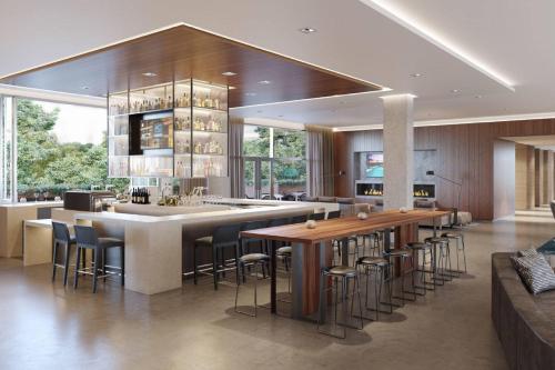 a kitchen with a large island with bar stools at AC Hotel by Marriott San Jose Santa Clara in Santa Clara