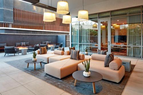 a lobby of a hotel with couches and tables at AC Hotel by Marriott San Jose Santa Clara in Santa Clara