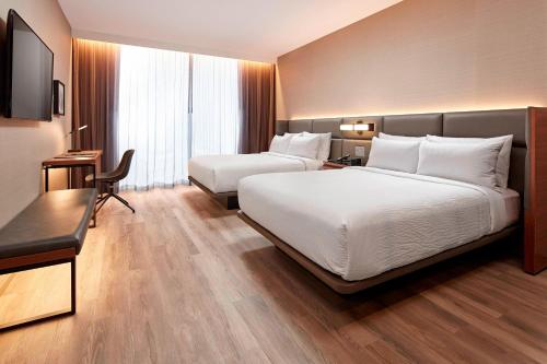a hotel room with two beds and a desk at AC Hotel by Marriott Sunnyvale Cupertino in Sunnyvale