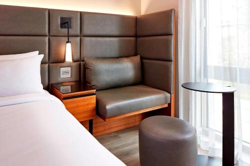 a bedroom with a bed and a chair and a table at AC Hotel by Marriott Sunnyvale Cupertino in Sunnyvale
