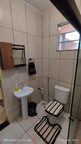a bathroom with a toilet and a sink at Casa de praia Região dos Lagos - Unamar - Cabo Frio RJ in Cabo Frio