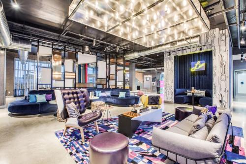 a lobby with couches and chairs and tables at Aloft Dallas Arlington Entertainment District in Arlington