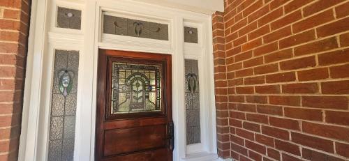 a door with a stained glass window next to a brick wall at Fitzroy Lodge Cowra in Cowra