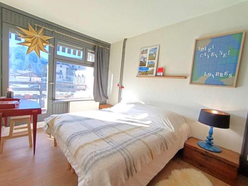 une chambre avec un lit, un bureau et une fenêtre dans l'établissement T2 confortable pour 4 pers avec balcon sud et parking à 1700m d'altitude - FR-1-457-362, à Saint-Lary-Soulan