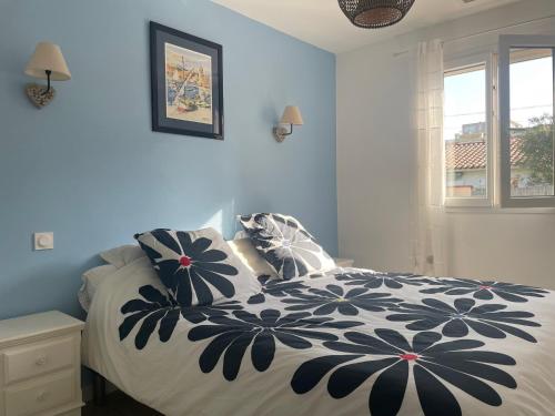 une chambre avec un lit avec une couette noire et blanche dans l'établissement Maison à Argelès - 2 chambres - Jardin, Parking, WiFi, Clim - FR-1-309-487, à Argelès-sur-Mer