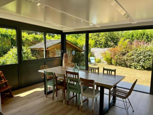 une salle à manger avec une table et quelques chaises dans l'établissement Maison moderne près du lac avec jardin et véranda à Sanguinet, pour 10 personnes - FR-1-319-584, à Sanguinet