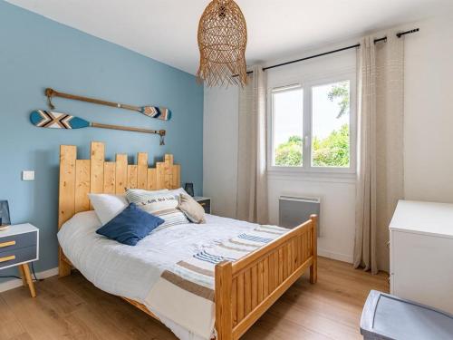 une chambre avec un lit aux murs bleus et une fenêtre dans l'établissement Maison moderne près du lac avec jardin et véranda à Sanguinet, pour 10 personnes - FR-1-319-584, à Sanguinet