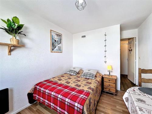 une chambre avec un lit avec une couverture à carreaux dans l'établissement Studio skis aux pieds, accès piscine, centre proche - FR-1-267-306, à Villarembert