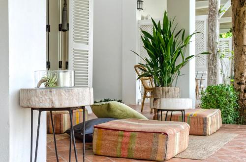a porch with a bunch of ottoman tables and chairs at Chic stay HANA Boutique hotel in Luang Prabang