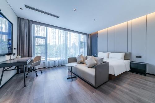a hotel room with a bed and a desk at Atour Hotel Panzhihua East District Jinhai Century City in Panzhihua