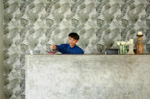 a man sitting at a counter with a plate of food at Chic stay HANA Boutique hotel in Luang Prabang