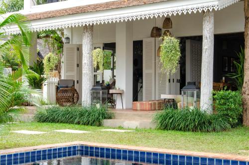 a house with a swimming pool in front of it at Chic stay HANA Boutique hotel in Luang Prabang
