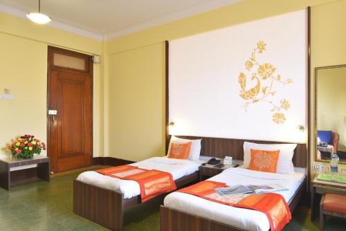 ein Hotelzimmer mit 2 Betten und einer Wand in der Unterkunft Sea Green Hotel in Mumbai