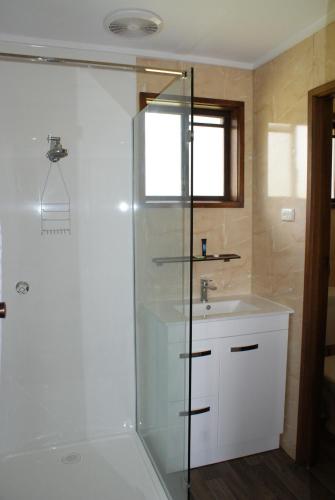 a bathroom with a shower and a sink at Warrnambool Motel and Holiday Park in Warrnambool