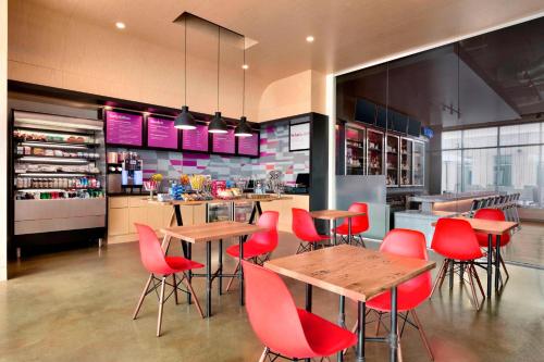 a restaurant with red chairs and tables in a kitchen at Aloft Dallas Love Field in Dallas