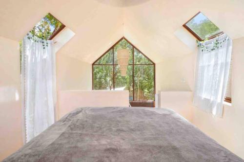 a bedroom with a bed with a large window at Loft Cabins In Cenotes Natural Park Tulum in Tulum