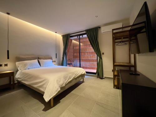 a bedroom with a bed and a large window at Estacion Alameda Downtown in Orizaba