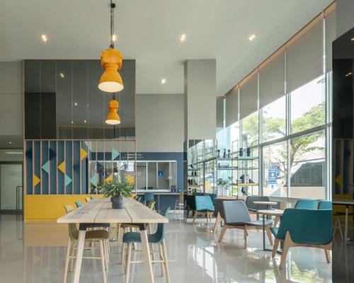a dining room with tables and chairs and windows at A family room at Lumpini Ville Sukhumvit 101-1 by Pikul in Bangkok