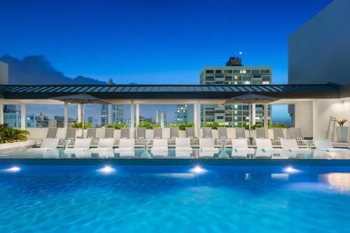 a swimming pool with chairs and a building at AC Hotel by Marriott San Juan Condado in San Juan