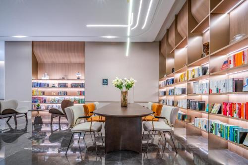 a library with a table and chairs and bookshelves at Atour Hotel Panzhihua East District Jinhai Century City in Panzhihua
