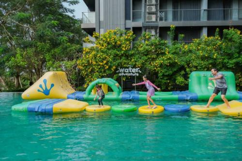 a group of people playing in the water at a water park at Balcony Seaside Sriracha Hotel & Serviced Apartments in Si Racha