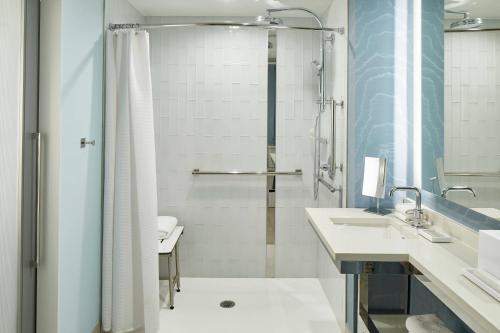a bathroom with two sinks and a shower at Renaissance Charlotte SouthPark Hotel in Charlotte