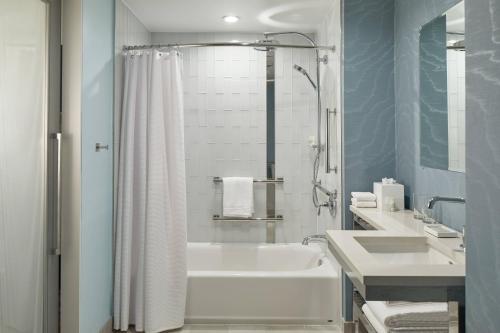 a white bathroom with a tub and a sink at Renaissance Charlotte SouthPark Hotel in Charlotte