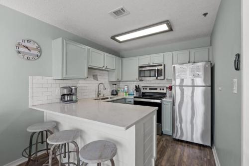 une cuisine avec des armoires blanches et un réfrigérateur blanc dans l'établissement Oar'asis Heated Pool Beach View, à Destin