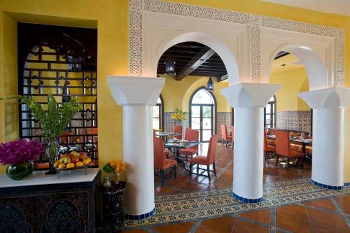 a dining room with white columns in a restaurant at Villa Maroc Resort in Pran Buri
